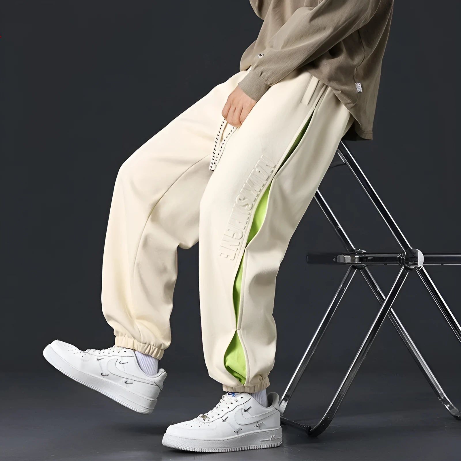 Man wearing loose-fit black trousers with printed stitching detail and a banded ankle cuff.