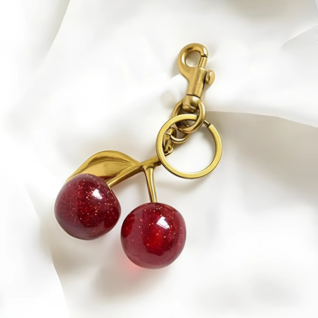 Red zinc alloy 3D cherry keychain pendant with metal loop for keyring attachment.