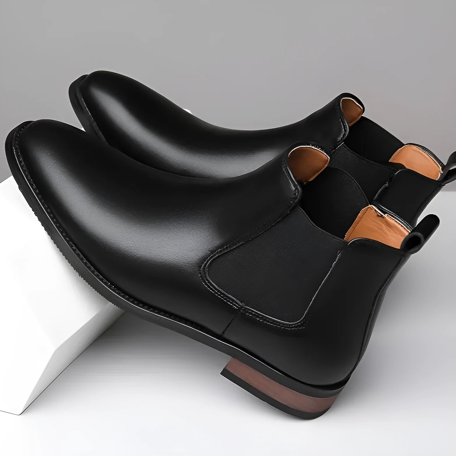 Men's black pointed toe Chelsea boots with mid-calf height and decorative stitching
