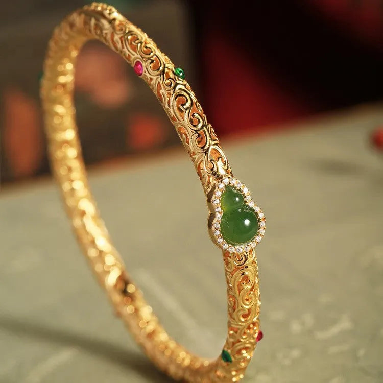 Retro-style open copper bracelet with a detailed gourd charm on a wrist.