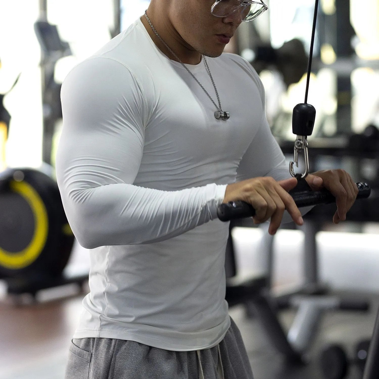 Man wearing black slim fit long sleeve fitness tights for running or gym workout.