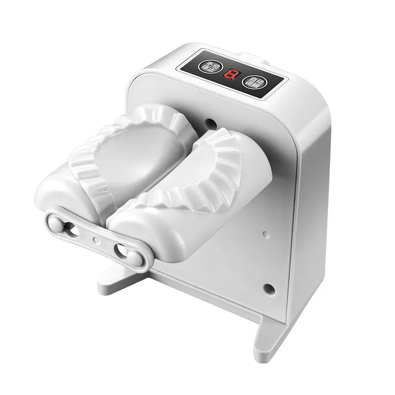 White automatic electric dumpling maker machine with USB charging cable, brush, and spoon on a kitchen counter.