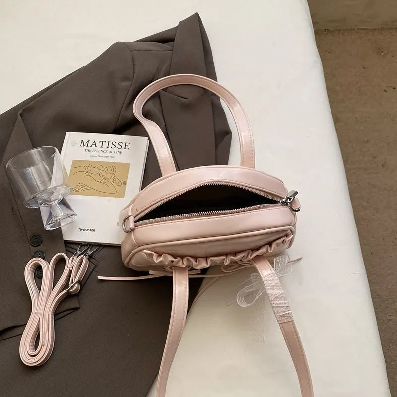 Women's casual PU shoulder handbag with bandage bow design in milky white colour showing sewing thread details