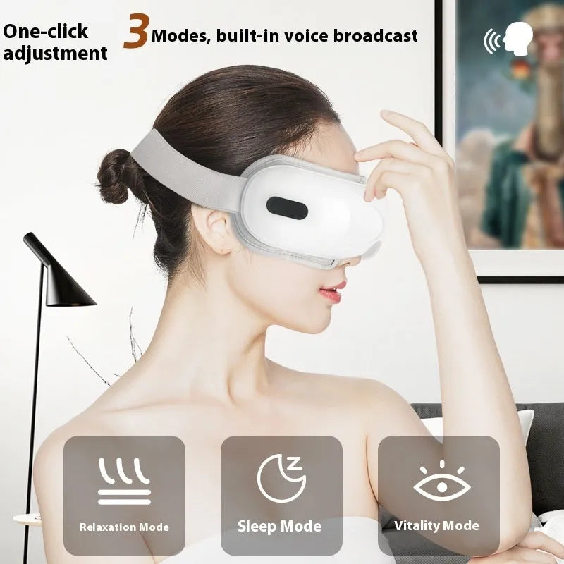 White rechargeable eye massager with hot compress and airbag massage functions on a flat surface