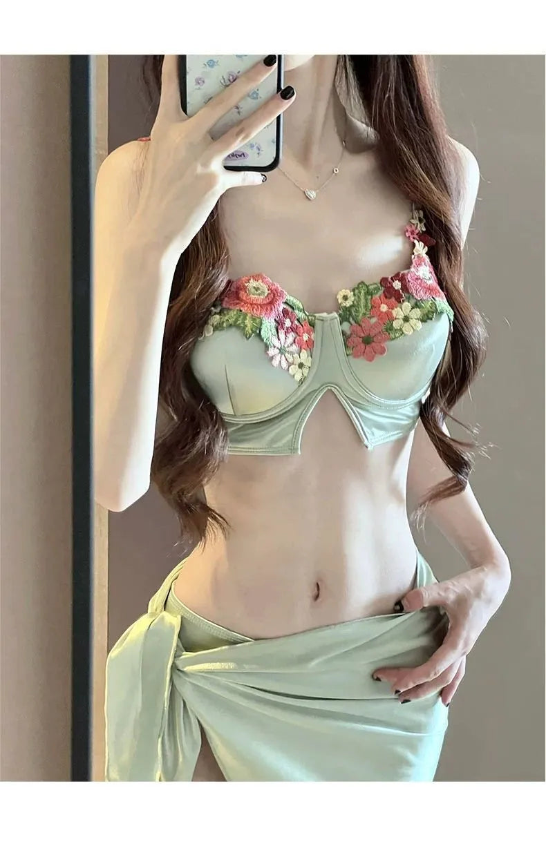 Green women's bikini three-piece set with triangle top, briefs, and skirt cover-up