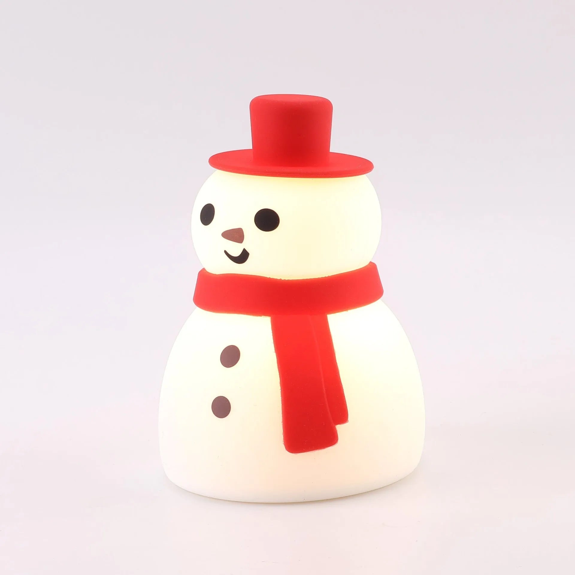Cartoon snowman shaped silicone night lamp with warm light on a desk