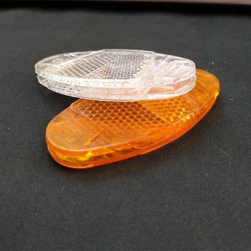 White and yellow plastic bicycle spoke reflectors showing 7.2cm length measurement