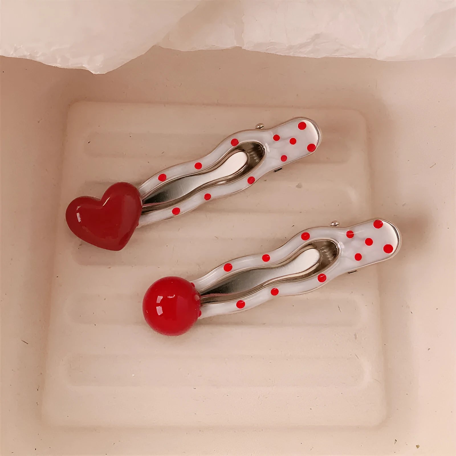 Red stereo love heart-shaped hairpin with French retro dots and willow leaf decoration on a white background.