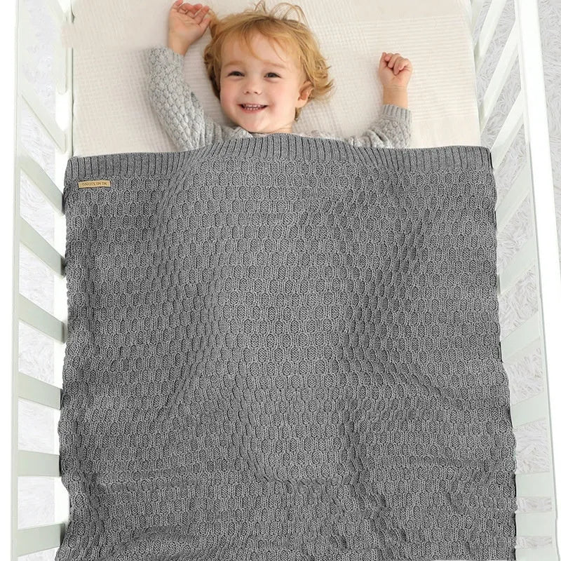Solid colour baby hug blanket with raised 3D lines, shown in a neutral colour, folded to show size.