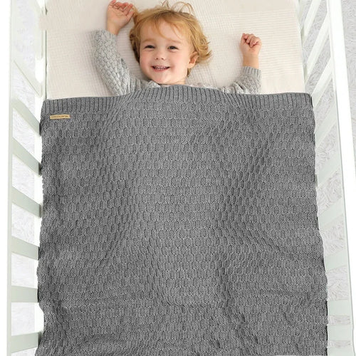 Solid colour baby blanket with textured three-dimensional lines, shown in beige khaki.