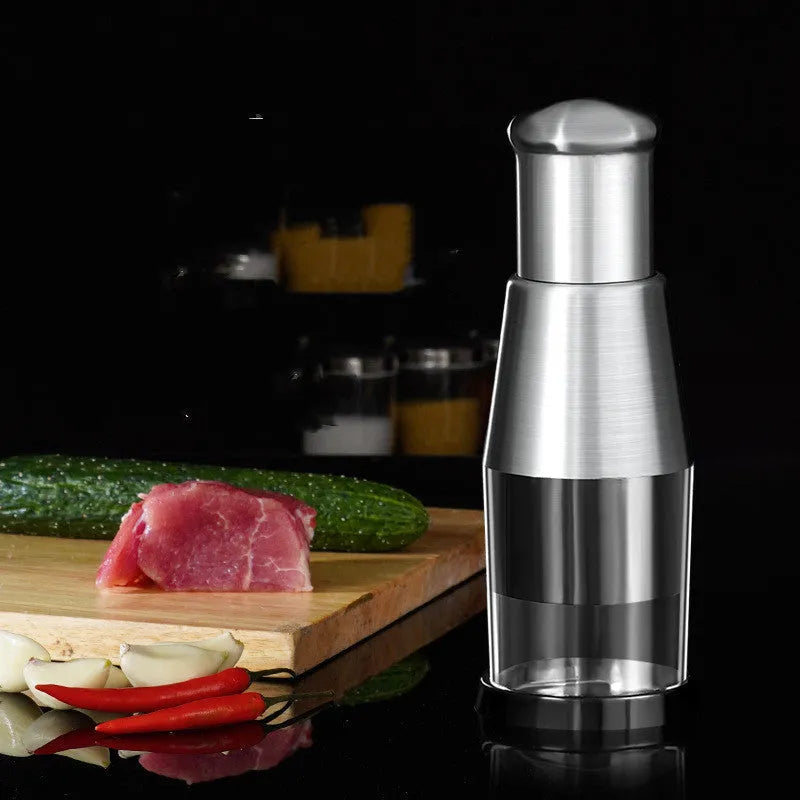 Black manual garlic press and onion chopper with stainless steel blades on a kitchen counter.